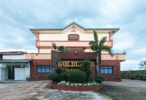 UrdanetaRedDoorz @ Goldland Spring Resort Urdaneta City的前面有标牌的建筑物