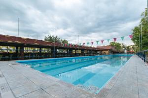 UrdanetaRedDoorz @ Goldland Spring Resort Urdaneta City的一座悬挂着旗帜的建筑里的大型游泳池