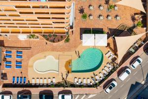 罗萨斯圣马克威望酒店的享有游泳池和大楼的顶部景致