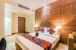 孟买FabHotel RK International的一间卧室配有一张木墙床