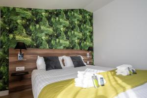 拉罗谢尔ATHOME RESIDENCE ET SPA的一间卧室配有一张带绿色壁纸的床