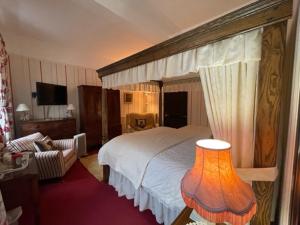普利布里奇Barton Hall Country House的一间卧室配有一张带天蓬的大床