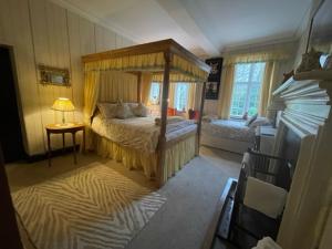 普利布里奇Barton Hall Country House的一间卧室配有一张天蓬床和一张桌子