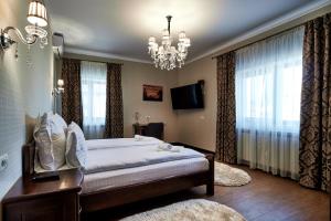 Chilia VecheCasa Chilia Resort&Spa的一间卧室配有一张大床和一个吊灯。