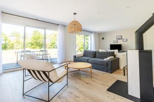 贝诺代Les Peupliers - maison de vacances avec jardin的客厅配有沙发和桌子