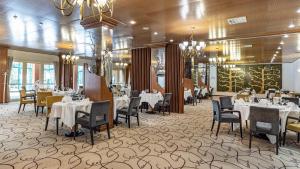 普利特维采湖杰泽罗酒店的用餐室配有桌椅和吊灯。