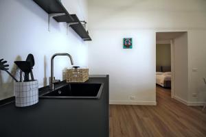 拉奎拉Casa Maggie的一个带水槽的黑色厨房和一间卧室