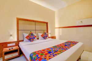 孟买FabExpress Super 7 Inn的一间卧室配有一张大床和色彩缤纷的毯子