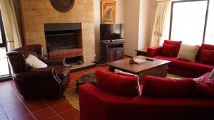 纳纽基Nyikani Villa Olpejeta的客厅配有红色家具和壁炉