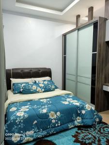 淡文Tambun Hillview Cottage的一间卧室配有一张带蓝色棉被的床