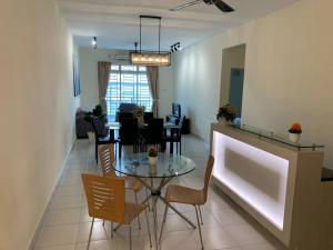 新山Tebrau City Residence,Warm Suite by Antlerzone的用餐室以及带桌椅的起居室。