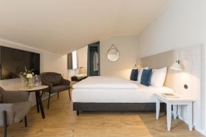 奥斯特巴德·哥伦Koopmanns Hotel und Lädchen的酒店客房带一张床、一张桌子和椅子