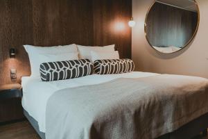 朗伊尔城方垦小屋酒店的一间卧室配有一张带镜子的大床