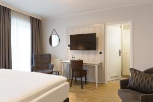 奥斯特巴德·哥伦Koopmanns Hotel und Lädchen的配有一张床和一张书桌的酒店客房