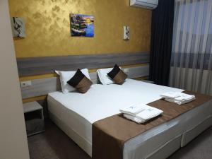 基尔科沃Хотел Чинар Кирково的一间卧室配有一张大床和毛巾