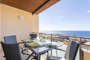 圣克鲁斯-德特内里费Chalet con vistas al mar en Santa Cruz de Tenerife的阳台配有餐桌和椅子,享有海景