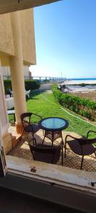 阿莱曼Beach Front Standalone Villa, Virginia Beach North Coast - فيلا اول صف بحر و شاطئ قرية فرجينيا بيتش طلعت مصطفى的一个带桌椅的庭院和海滩