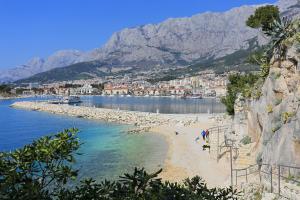 马卡尔斯卡Apartments and rooms with WiFi Makarska - 11063的水边的海滩上有人