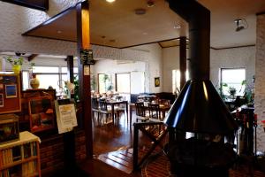 富士河口湖作弥宾馆的一间带壁炉的餐厅,位于客房中间