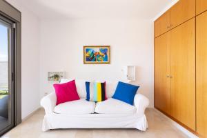 圣克鲁斯-德特内里费Chalet con vistas al mar en Santa Cruz de Tenerife的客房内的白色沙发上配有色彩缤纷的枕头
