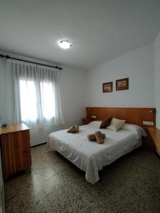 塔马留La Caseta的一间卧室,配有一张带两个泰迪熊的床
