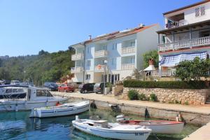 萨利Apartments and rooms by the sea Zaglav, Dugi otok - 8144的一群船在建筑物旁边的水中