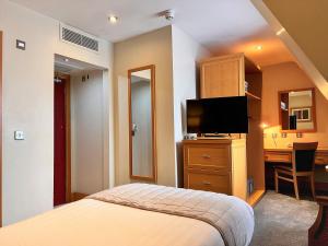 都柏林贝雷斯福德酒店的酒店客房配有一张床、一张书桌和一台电视。