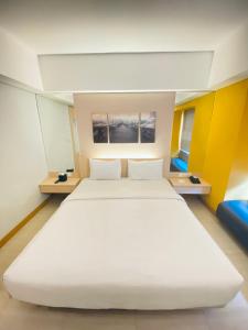 库塔太阳皇家酒店的一张白色的大床,位于拥有黄色墙壁的房间