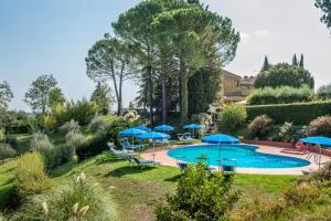圣吉米纳诺La Ripa - Appartamento Il Fienile的一个带蓝伞和椅子的游泳池