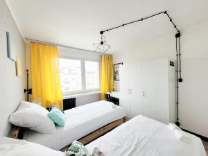 罗兹Pomorska Rooms的配有黄色窗帘的客房内的两张床