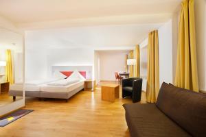 奥托博伊伦赫希AKZENT酿酒厂酒店的客厅配有床和沙发