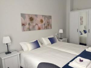 CastandielloEl Angliru 3 con Wifi Incluido的卧室配有一张白色大床,墙上挂有绘画作品