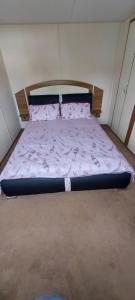 斯凯格内斯Springs 46 by Vilija Southview Leisure Park Skegness的小型客房内的一张床位,配有粉红色的被子