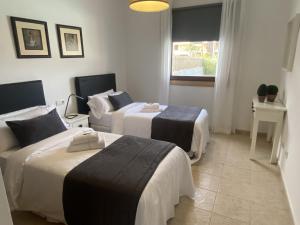 普拉亚布兰卡Villalia Capri的酒店客房设有两张床和窗户。