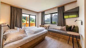 塞斯托Im Wiesengrund Apartments的一间卧室设有一张床、一台电视和窗户。