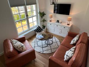 奥斯赛拜-屈隆斯博恩stilvolle Ferienwohnung Sweet Magnolia的客厅配有两张沙发和一张桌子