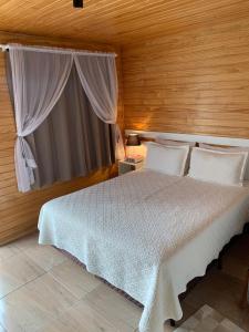 乌鲁比西Aconchego do Sereno Exclusive Chales的卧室配有白色的床和窗户。