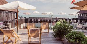罗尔沙赫莫扎特酒店的木制甲板上的一组椅子和遮阳伞