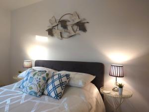 金斯林Avocet Lodge, Snettisham的一间卧室配有一张带枕头的床和两盏灯。