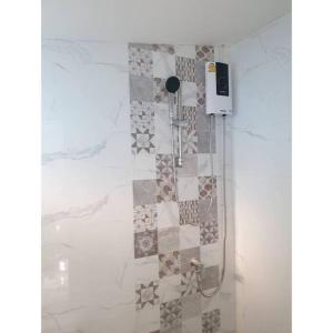 七岩Cha-am Beach Vacation Home的带淋浴的浴室(带瓷砖墙)