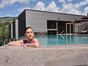 瓦格赖恩瓦格赖恩运动酒店的躺在房子旁边的游泳池里的女人