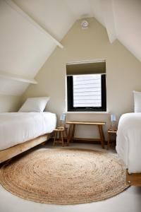 内斯Van Heeckeren Apartments & Suites Nes的一间卧室设有两张床、一个窗户和一个地毯。