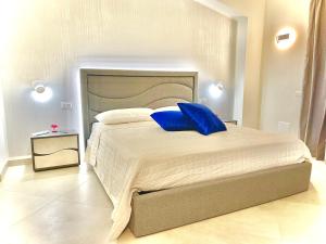 特罗佩阿Imperial Rooms Tropea的一间卧室配有一张带蓝色枕头的大床
