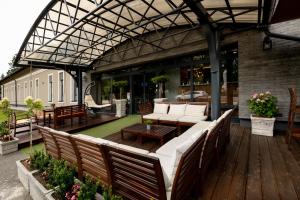 松博特海伊加尔达酒店的户外庭院配有白色的沙发和桌子。