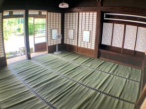 松崎町ゲストハウス大安吉田的一间空房间,设有绿色地板和风扇