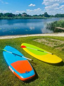 YasnogorodkaEden Resort的两个冲浪板坐在草地上,靠近水体