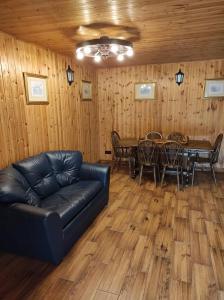 普拉特利艾Žilių sodyba的客厅配有真皮沙发和桌子
