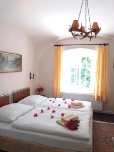 多克西Hájovna hradu Houska的一间卧室,床上有红色的鲜花