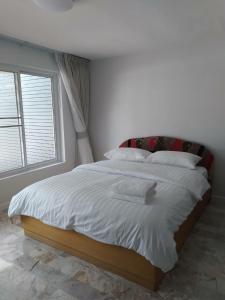 七岩Cha-am Beach Vacation Home的卧室配有一张大白色床和窗户