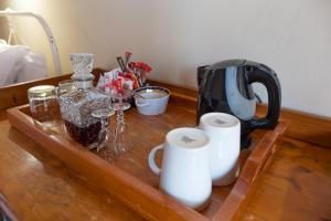 德尔斯特鲁姆Dullstroom Inn的一张木桌,上面有咖啡壶和杯子